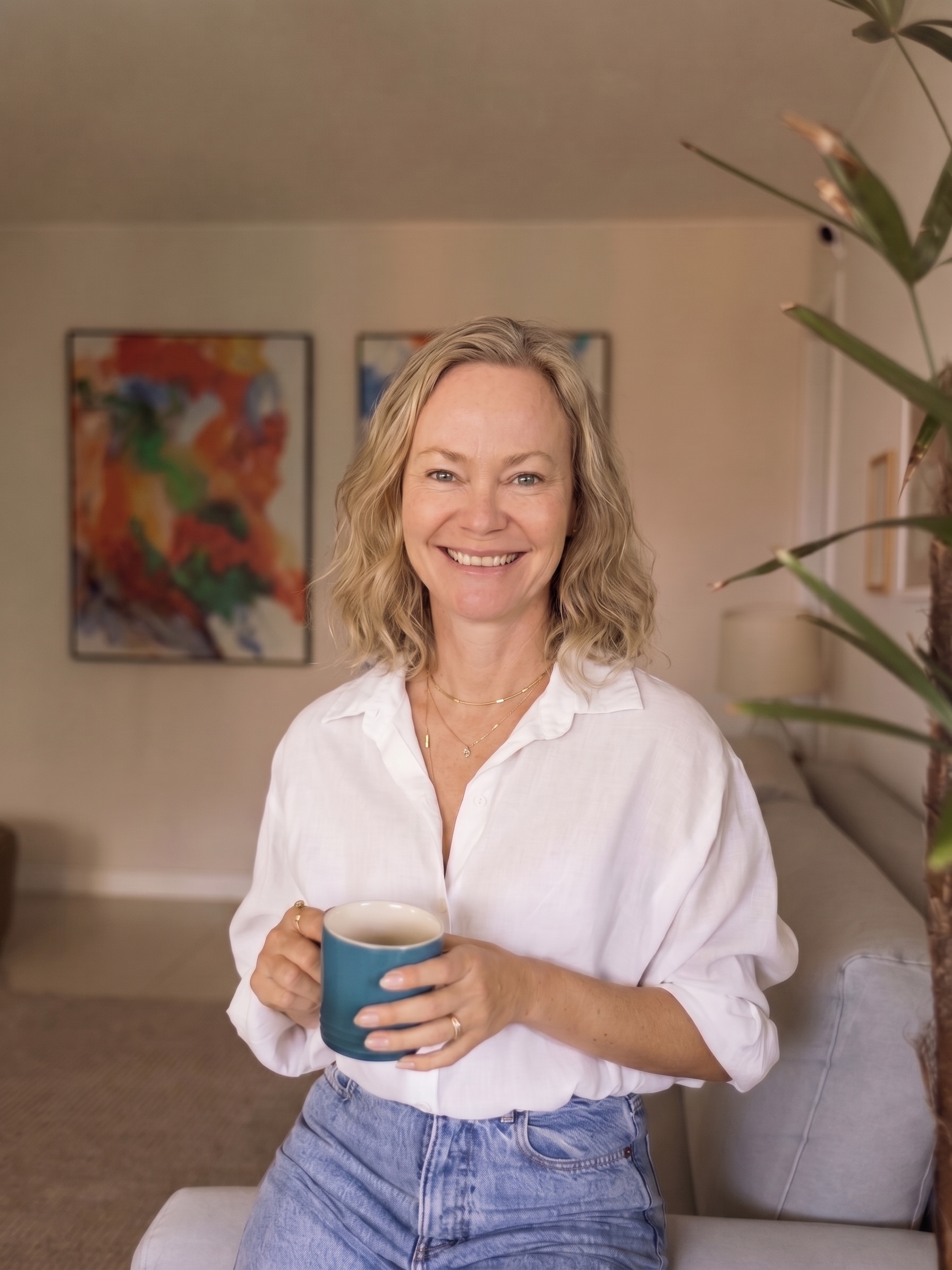 Nina Kolari holding a mug in her living room